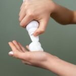 Preparing shaving foam from dispenser for grooming close-up.